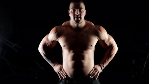 Muscular Man Posing in Dark Studio