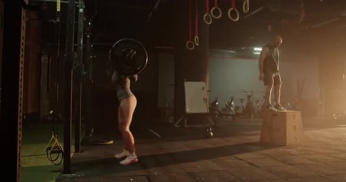 Sportsman and Woman Training Together in Gym