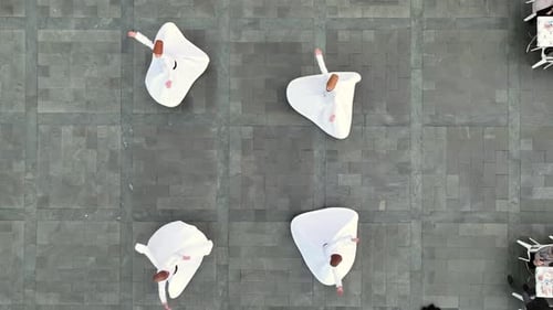 Aerial View of Rotating People in White Robes