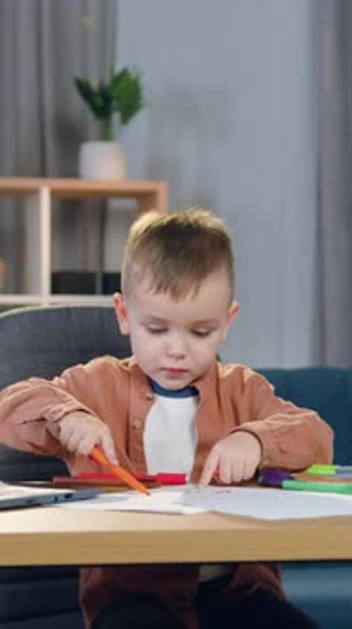 Young Boy Drawing with Markers at Home