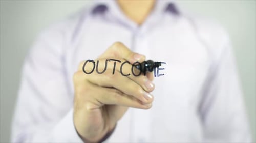 Hand Writes Outcome on Clear Surface