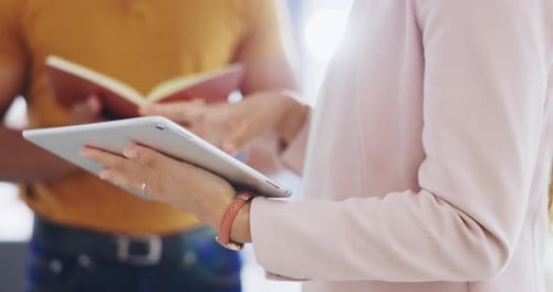Individuals Working with Tablet and Book