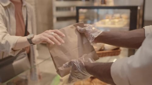 Bakery Salesman Handing Takeaway Order to Customer