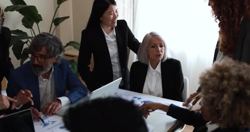 Multiracial business team discussing financial strategy inside bright modern bank office