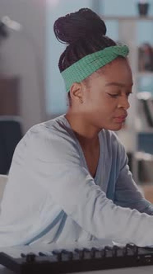 A Woman in a Green Headband Plays Keyboard Immersed in Music