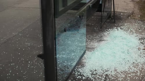 Shattered Glass Window Rests on Ground Near Building