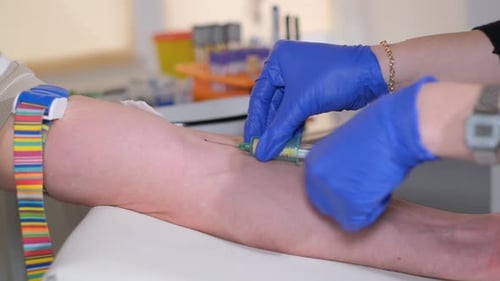A Doctor in the Laboratory Takes a Blood Test From a Vein Closeup Without a Face