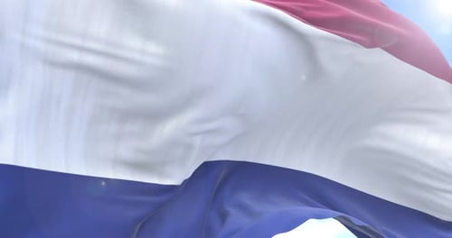 Netherlands Flag Waving in Wind Against Blue Sky