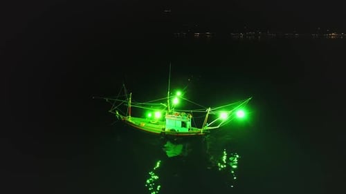 Fishing Boat with Green Lights Illuminating the Night in Koh Phangan Thailand