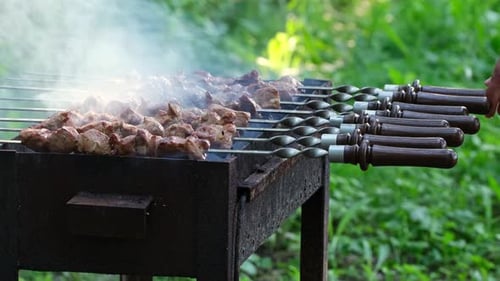 Kebab cooking outdoors on metal skewer. Marinated barbecue meat cooked at barbeque