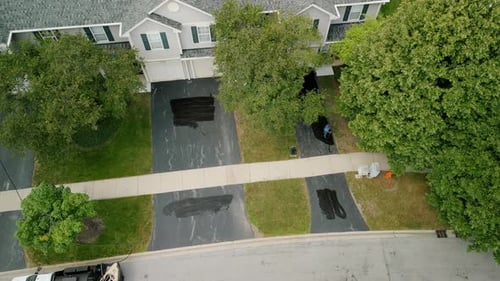 Aerial Wide View of Driveway Sealcoating Pavement Near Private Houses in the Suburbs