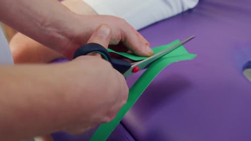 Cutting Kinesiology Tape with Scissors in Clinic