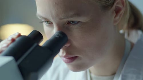 Konzentrierte Ärztin schaut ins Labormikroskop