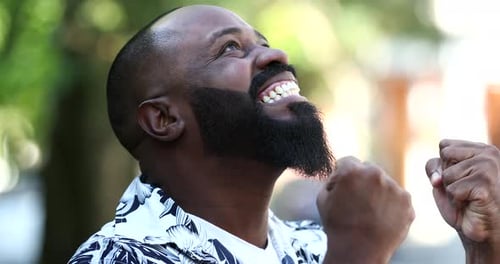 Bearded Man Celebrating Success with Clenched Fists Outside