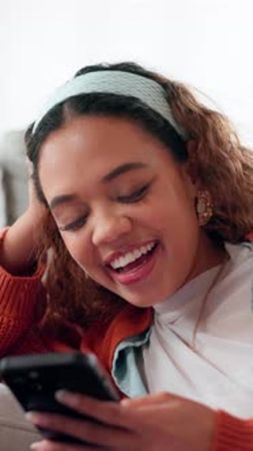 Happy Woman Laughing While Using Phone Indoors