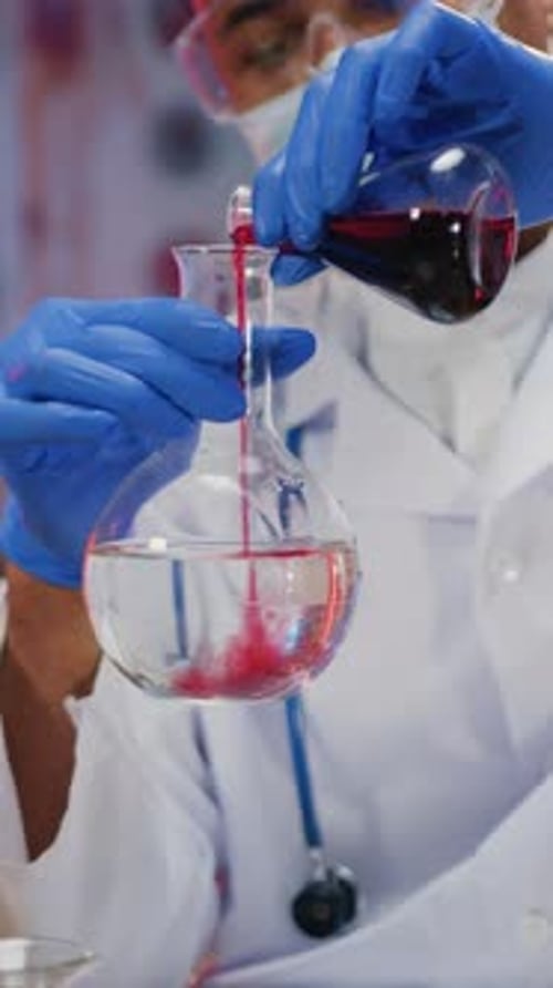 Scientist Mixing Red Liquid in Laboratory Beaker