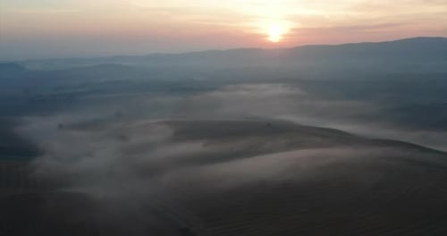 Aerial shot of scenic panoramic misty view of Italian hills at a sunrise.