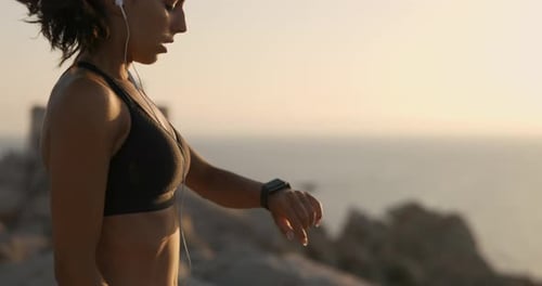 Woman Checking Smartwatch After Workout Near Ocean