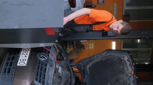 Mechanic Working on Car Engine in Garage