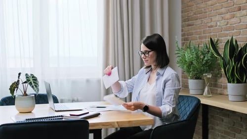 Woman Reads Letter at Desk