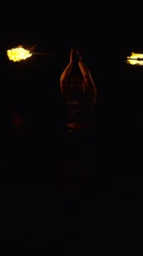 Nighttime Fire Dancing Performance with Glowing Flames and Dynamic Poi Movements Captured in