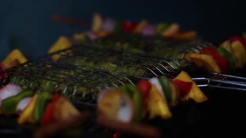 Close up of hand spraying water on barbecue. Handheld, shallow focus