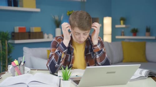 Stressed Student Working at Desk with Laptop