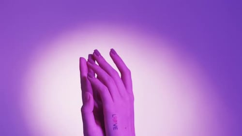 Elegant Hands Rubbing Tenderly in Purple Light