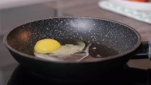 Casser des œufs frais dans une poêle pour préparer le petit-déjeuner
