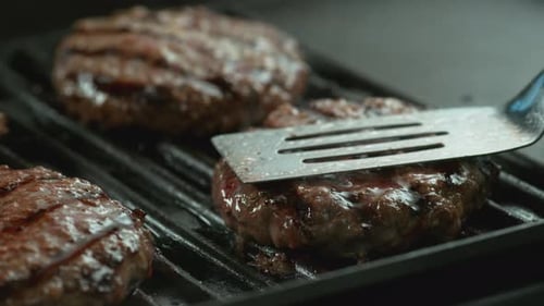 Closeup Shot Of Hamburgers Cooking On Grill, Slow Motion.