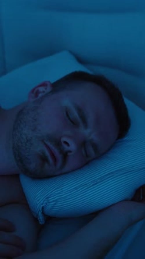 Man sleeping restlessly at night