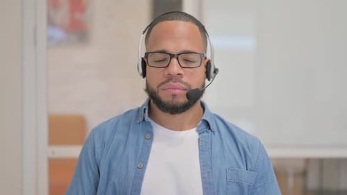 African Man with Headset Looking at Camera in Call Center