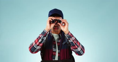 Jumelles, randonnée et voyages avec l'homme, bien-être et observation des oiseaux sur fond de studio bleu
