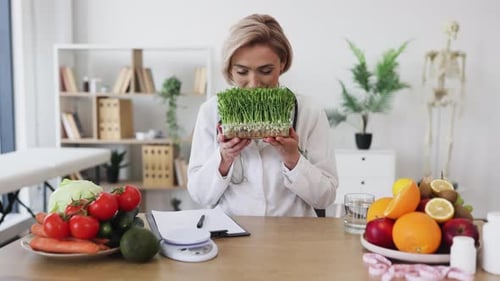 Woman Doctor Holding Fresh Greens in Medical Office