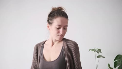 Young Woman Dancing Joyfully Indoors By a Plant