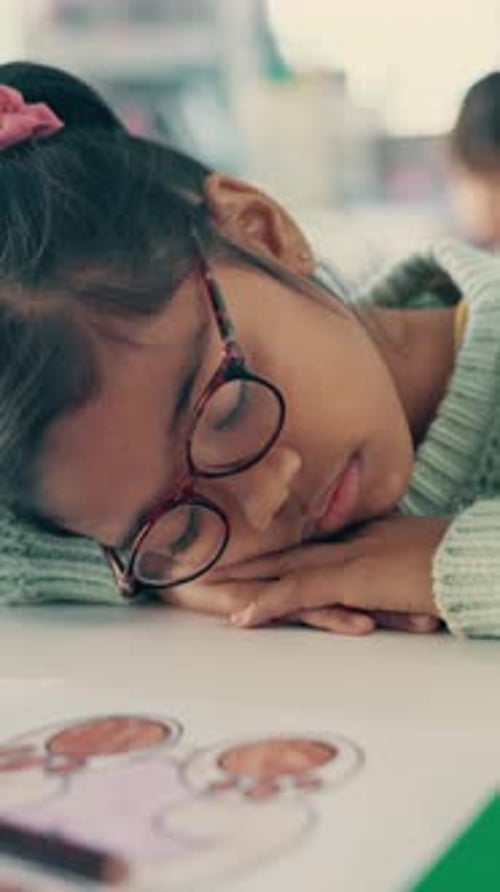 Tired, sleeping and child in classroom at school with burnout for education, learning or knowledge