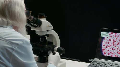 Senior Scientist Using Microscope in Laboratory