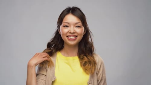 Smiling young woman portrait on gray background