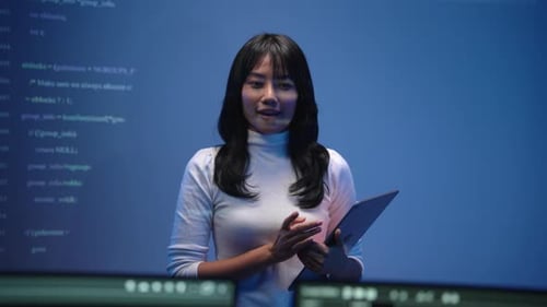 Professional Woman Presenting Software Code in High-Tech Office Setting