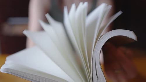 Student flips through the pages of their notebook. College student flips through the paper pages of