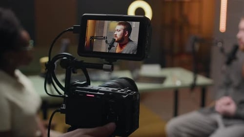 Kameramann passt die Kamera während der Podcast-Aufnahme im Studio an