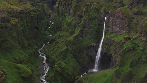 Aerial View of Lush Green Canyon with Waterfall in Iceland