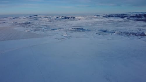 Bright day in wild fields during winter time with hills on background