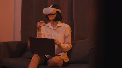 Woman Exploring Virtual Reality with VR Headset and Laptop