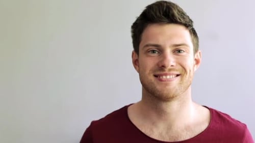 Smiling young man in red shirt close up