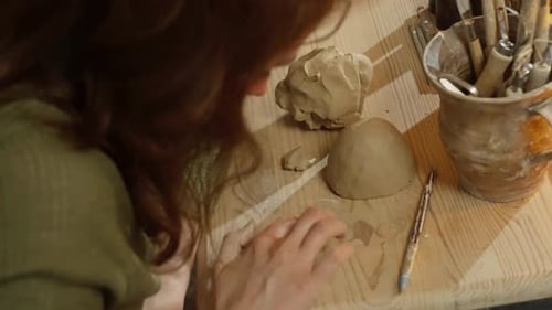 Closeup of a Ceramicist's Hands Sculpting Clay in the Workshop