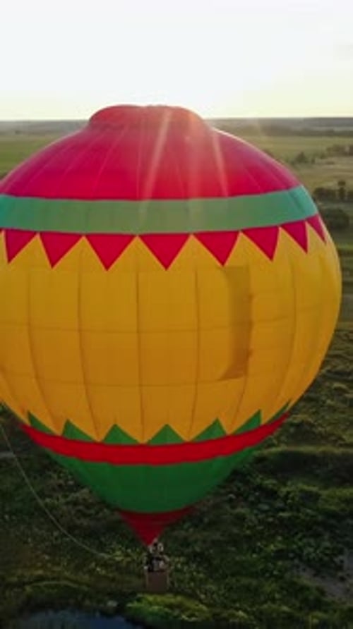 Colorful Hot Air Balloon Drifting Over Rural Landscape