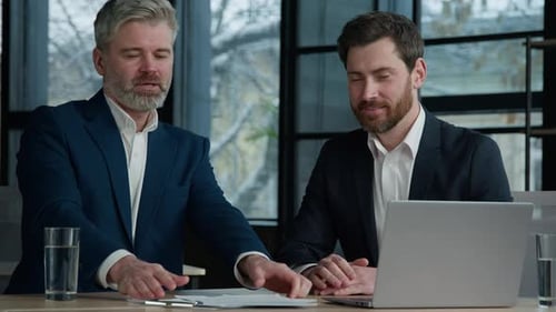 Businessmen Meeting in Office Reviewing Documents