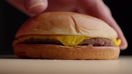 Hand Picking Up a Cheeseburger