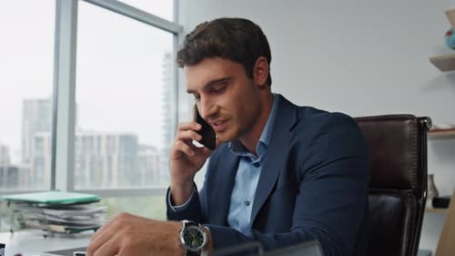 Smiling entrepreneur talks mobile phone strategy with partner remotely in office